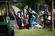 Police dragged a person from a tent as they cleared tents and possessions from the east side homeless encampment at Powderhorn Park in Minneapolis on 