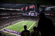The sun sets behind a silhouette of the Minneapolis skyline as Vikings plays took the field during a game last season.