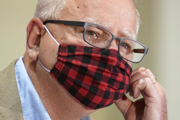 Minnesota Gov. Tim Walz wore his buffalo plaid cloth mask during a news conference Wednesday to announce statewide mask mandate, starting Saturday.