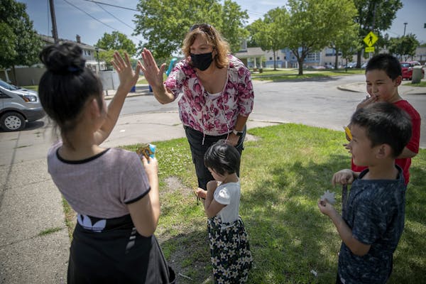 The Ramsey County Sheriff's outreach Cmdr. Mary Kay Skelly gave air high-fives to children after giving them freezes and stickers in the McDonough Hom