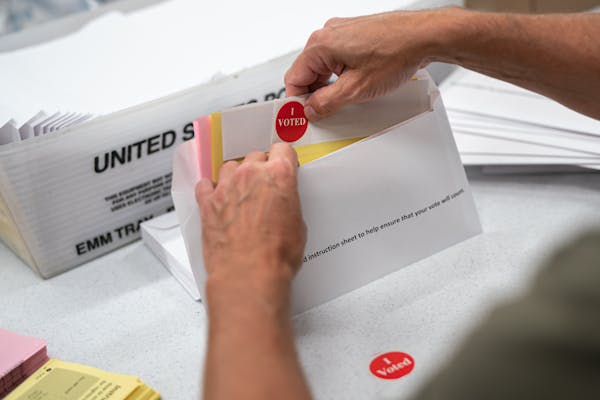 Minneapolis Elections and Voter Services staff prepared mail-in ballot envelopes, including an "I voted" sticker. Because of COVID-19, Minnesota is wa