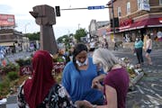 A prayer circle at 38th Street and S. Chicago Avenue in Minneapolis, the intersection where George Floyd was killed. Plans to reopen the area are begi