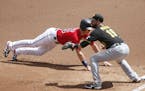 Minnesota Twins' Max Kepler, left, beats the throw to Pittsburgh Pirates first baseman John Ryan Murphy during a pickoff attempt in the first inning o