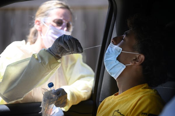 North Memorial RN Andrea Driskill administered a COVID-19 test to Dominick Brown, 15, July 29 behind the North Memorial Specialty Center in Robbinsdal