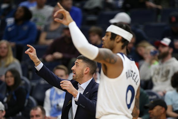 Timberwolves coach Ryan Saunders signals to his team alongside D'Angelo Russell in the second half of a game against the Mavericks, on March 1