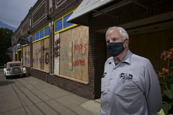 Mark Brandow, owner of Quality Coaches auto shop, stood for a portrait outside the shop, still boarded up, on Thursday, Aug. 20, 2020 in Minneapolis, 