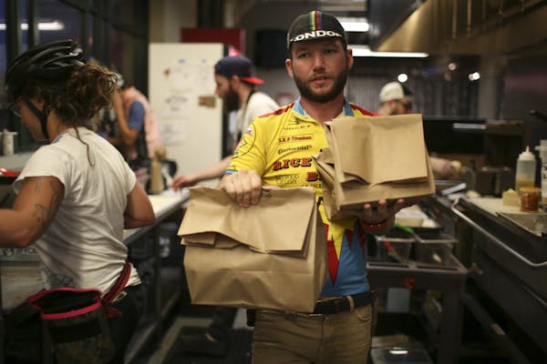 Jeff O'Neill carried three orders for delivery out of the kitchen at Taco Cat in the Midtown Global Market in Minneapolis.