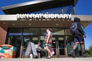 Library associate Matt Metzdorf met people at the door of Sun Ray Library in St Paul. It just reopened on a limited basis and is allowed to have no mo