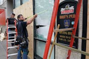Seth Johnson, a supervisor with MP Johnson Construction, measured a window to be boarded up at Brit’s Pub on Nicollet Mall.