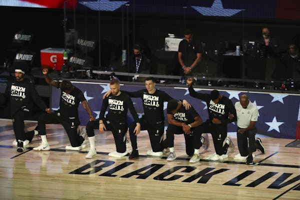 Brooklyn Nets players kneel for the national anthem before of Game 4 of an NBA basketball first-round playoff series, Sunday, Aug. 23, 2020, in Lake B