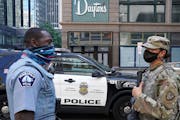 A Minneapolis police officer talked with a member of the Minnesota National Guard in downtown Minneapolis after a night of looting in August.