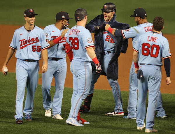 Twins designated hitter Nelson Cruz put his Twins-embroidered bath robe on right fielder Max Kepler after Kepler's late-inning heroics Tuesday night a