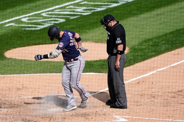 The Twins' Josh Donaldson kicks dirt on home plate after his home run prompting umpire Dan Bellino to eject him from the game during the sixth inning 
