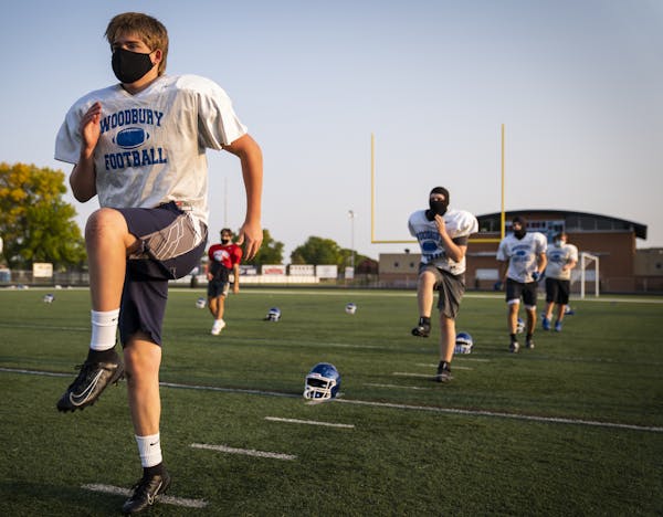 Garrett Prestholdt warmed up during Woodbury High School football practice on Monday. Teams resume play next month.