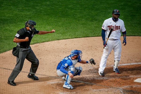Home plate umpire Jose Navas calls out Miguel Sano on strikes as Royals' Cam Gallagher catches the pitch