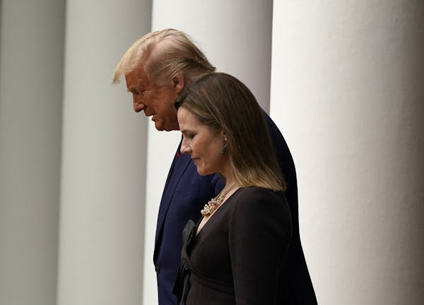 President Donald Trump walks with Judge Amy Coney Barrett to a news conference to announce Barrett as his nominee to the Supreme Court, in the Rose Ga