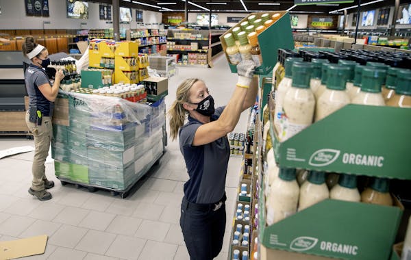 The Aldi team including Liz Burnard, left, and Gwen Klingelhoets, stocked the shelves in preparation for the 27th Avenue store's reopening next week.