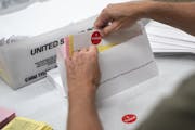 FILE - In this July 29, 2020, file photo, mail in ballot envelopes including an I Voted sticker are prepared in Minneapolis. Nevada's new vote-by-mail