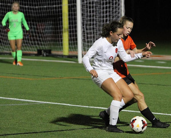 Stillwater forward Lexi Huber dribbles past White Bear Lake defender Maren Schoeberl near midfield during the first half Tuesday night at White Bear L