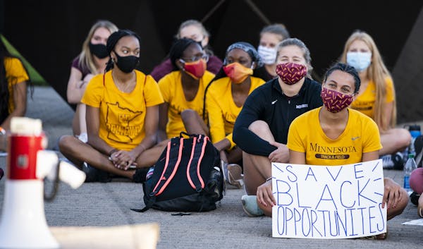 Gophers athletes staged a sit-in to protest sports programs being cut outside the McNamara Alumni Center on Wednesday.