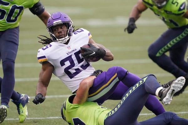 Vikings running back Alexander Mattison is brought down by the Seattle Seahawks during the first half.
