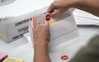 An elections worker prepares mail-in ballot envelopes in July in Minneapolis.