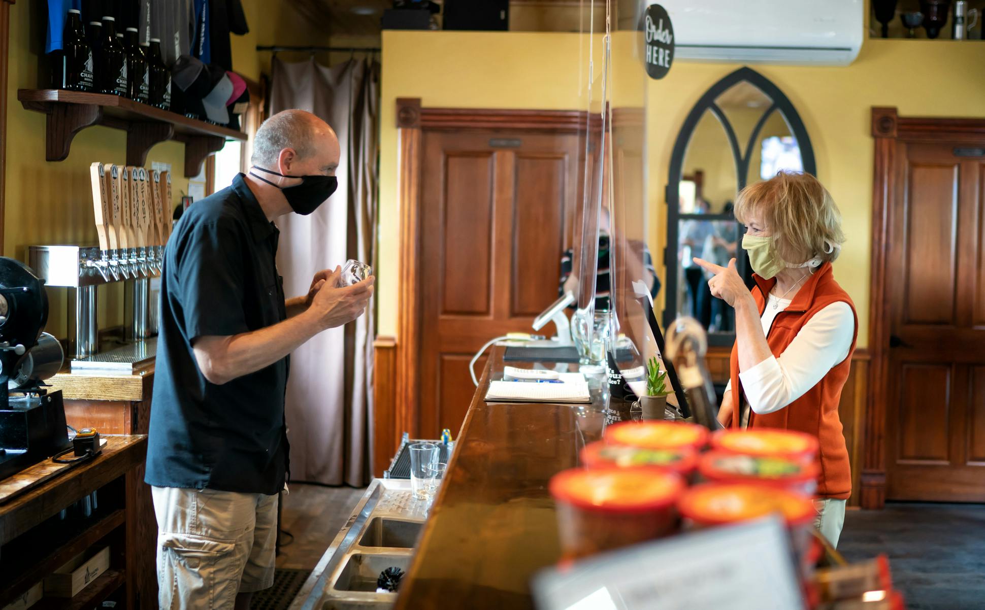 Sen. Tina Smith ordered a Blood Orange Pale Ale from co-owner Steve Schmidt, as she visited Chapel Brewing in Dundas, Minn., along with U.S. Rep. Angie Craig.