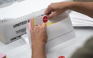 Todd Gallagher prepares mail in ballot envelopes including an I Voted sticker Wednesday, July 29, 2020 in Minneapolis. Absentee ballots are being requ