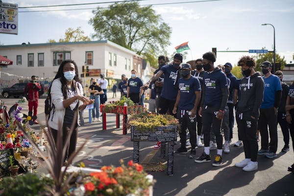Timberwolves players, coaches, and staffers listened to Jeanelle Austin, left, as she explained and interpreted the George Floyd memorial site for the