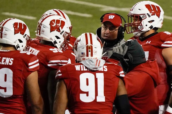 Wisconsin head coach Paul Chryst talks to his players during the first half against Illinois