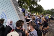 Protesters and homeless advocates turned a community library building on its side to try to salvage it after people living in Powderhorn Park in Minne