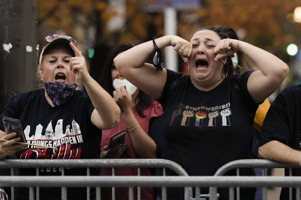 Supporters of President-elect Joe Biden taunt supporters of President Donald Trump as they protest outside the Pennsylvania Convention Center in Phila