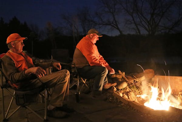 On the eve of the firearms deer opener, Terry Arnesen, left, and John Weyrauch cooked venison backstrap over an open fire from a whitetail taken last 
