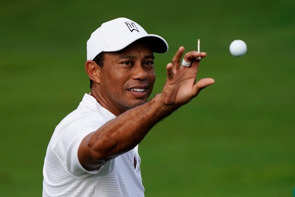 Tiger Woods catches a ball at the driving range during a practice round for the Masters