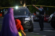 A family crossed Chicago Avenue as a Minneapolis Police officer lifted tape at a crime scene on July 23. Minneapolis residents are still torn over whe