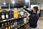 Chicago Lake Liquors owner John Wolf stocked shelves on Wednesday in preparation of the Thursday reopening after rioting and fires destroyed the inter