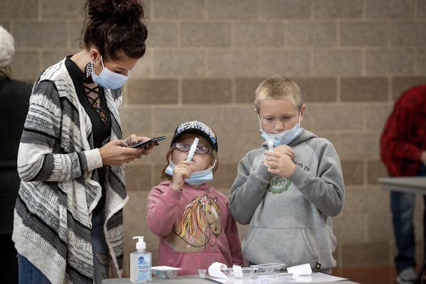 Tammi Bertram and her children Kristalyn, 6, center, and Bentley, 9, took a COVID-19 test at the new saliva testing center in Inver Grove Heights, Wed
