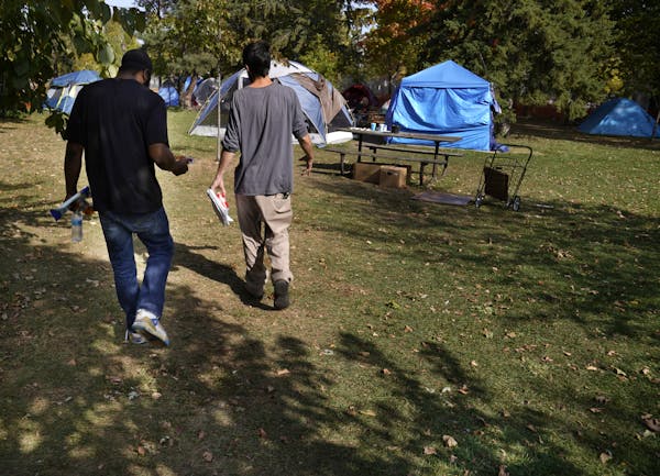 Brandon O’Neil Abrams, 31, left, and Brandon Harrison, 35, walked through Logan Park where they were both living in tents in October. Three encampme