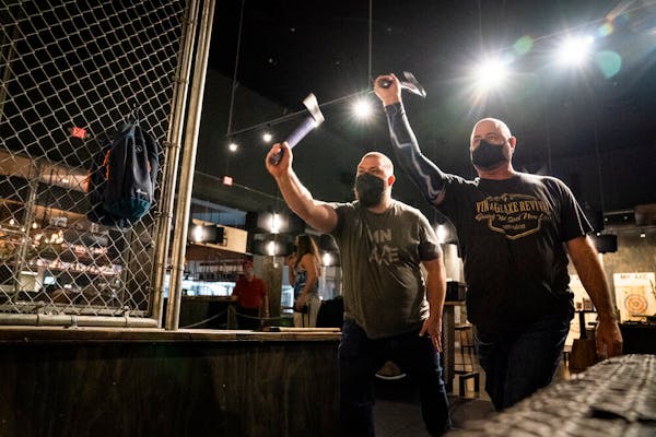 Dustin Kerr, left, and David Lewis practice dual throwing for the World Axe Throwing Championship at MN Axe in Eagan.