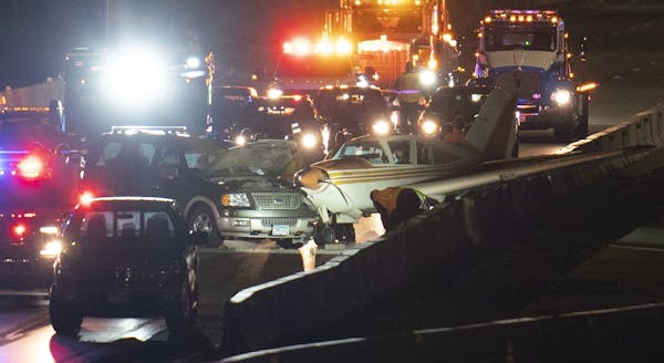 The single engine plane came to rest atop a concrete barrier on northbound I-35W in Arden Hills after hitting an SUV.
