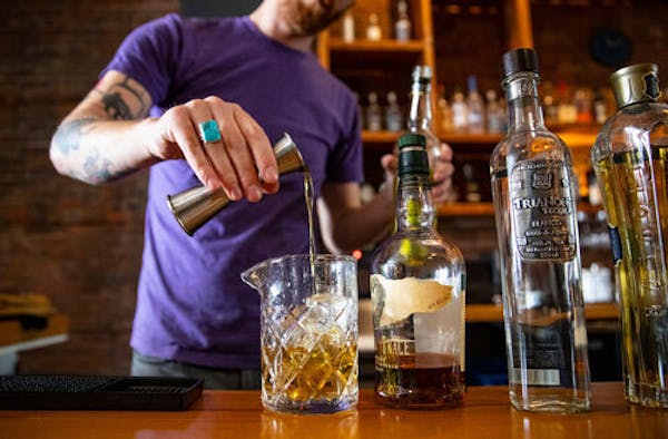 Noble Pour general manager Tyler Schwanke made one of the Duluth lounge’s signature cocktails, Midnight Song, behind the bar in December 2019.