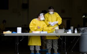 Elizabeth Santoro and Kristin Anderson, medics with the Minnesota Air National Guard 133rd Medical Group, prepared to administer COVID-19 tests at the