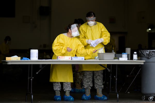 Elizabeth Santoro, left, and Kristin Anderson, medics with the Minnesota Air National Guard 133rd Medical Group, sanitized and prepared for their next