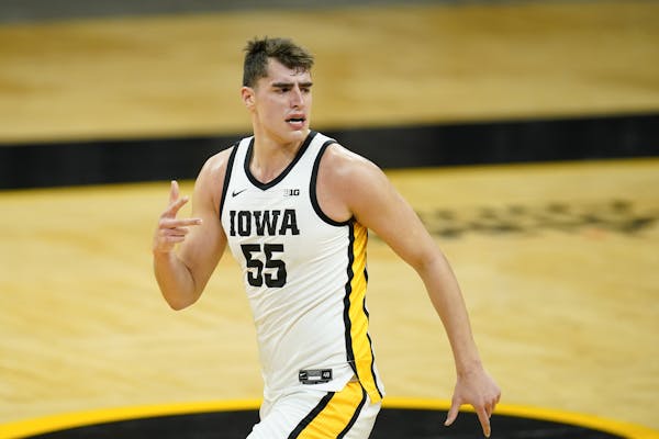 Iowa center Luka Garza celebrates after making a 3-point basket during the first half of an NCAA college basketball game against Purdue, Tuesday, Dec.