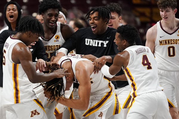 Minnesota forward Brandon Johnson (23) was mobbed by his teammates on the court after his multiple three point shots helped them beat the Iowa Hawkeye