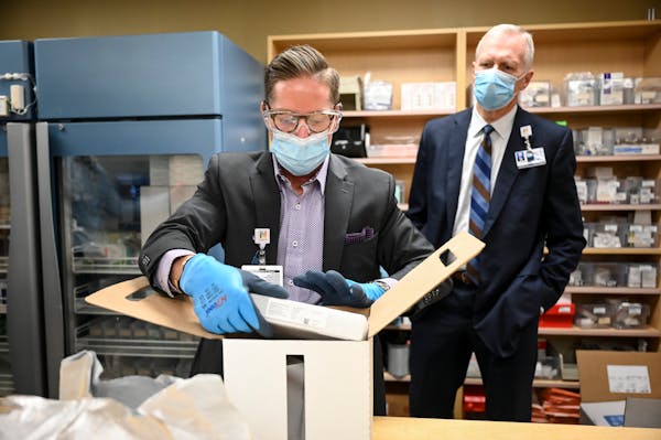 Paul Krogh, director of pharmacy services for North Memorial Health Hospital, unboxed the 975 doses of the Pfizer COVID-19 vaccine that arrived early 