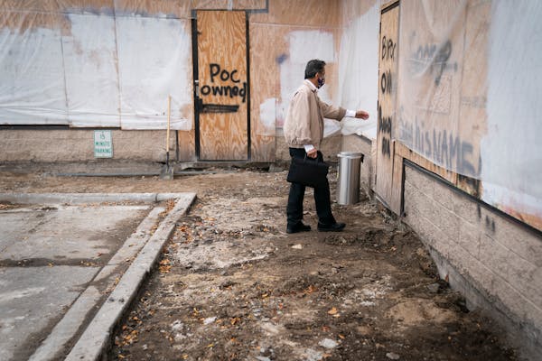 Subway owner Kim Seng tried to see If he could walk through the boarded up front door of his business as he checked in on the progress of reconstructi