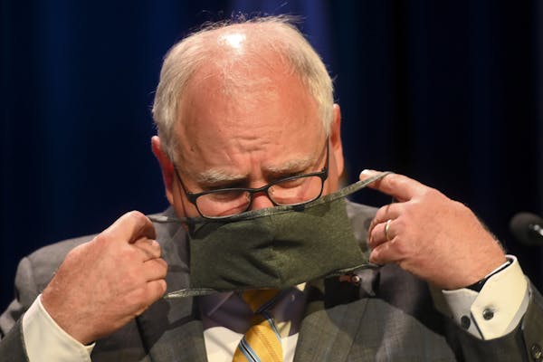Minnesota Gov. Tim Walz put his face mask at the conclusion of a July news conference.