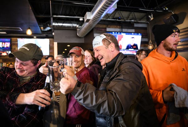 Dean Wedul of Lakeville, right of center, lifted his drink with friends at the bar at the Alibi Drinkery in Lakeville on Dec. 16.