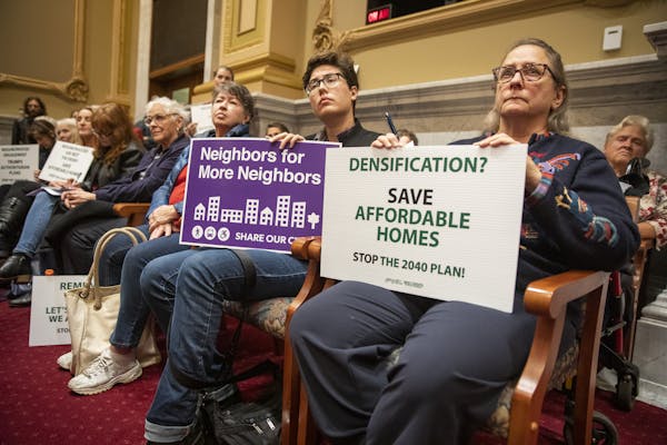 Nancy Przymus, from right, holds a sign against the 2040 Comprehensive Plan, as her neighbor Blue Delliquanti  holds a sign supporting the plan during
